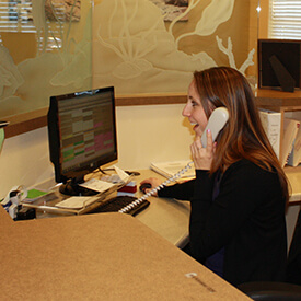 front desk worker talking on phone