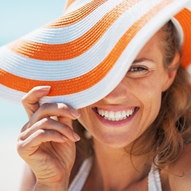 Woman with beach hat smiling brightly