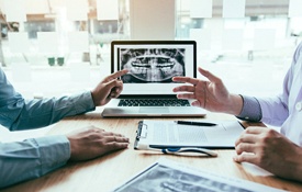 Two dentists discussing treatment for a patient.