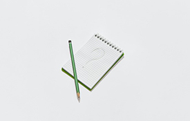 Green pencil and question mark on notepad