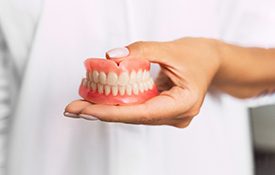 Dentist holding full dentures