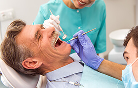 man smiling vibrantly in dental chair