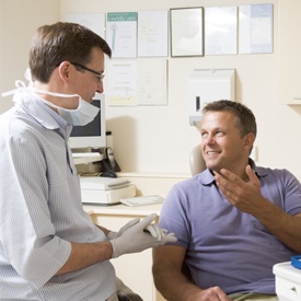 Man in dental chair talking to dentist