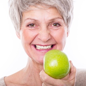 Senior woman eating apple