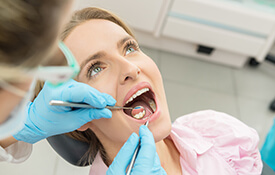 dentist checking patients smile