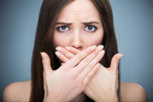 A woman covering her mouth with both hands