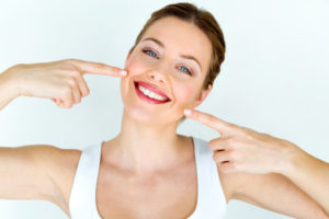 Woman pointing at her beautiful smile. 