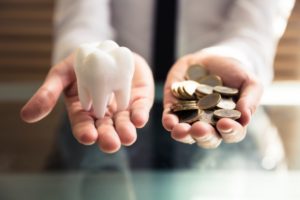 Someone holding a same-day crown in one hand and money in the other