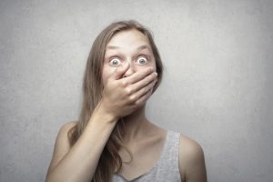 Shocked woman covering mouth with hand