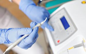 Gloved hand holding a dental laser